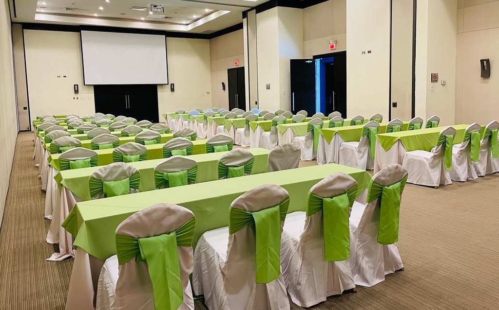 Salón de Convenciones con mesas y sillas en verde